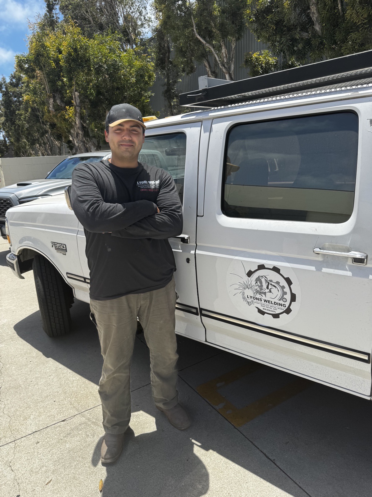 The owner of Lyons Welding standing in front of the company work truck